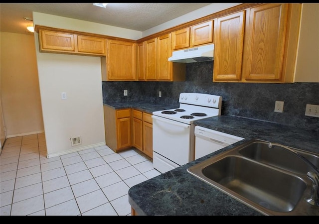 kitchen featuring tasteful backsplash, dark stone countertops, sink, white appliances, and light tile patterned flooring