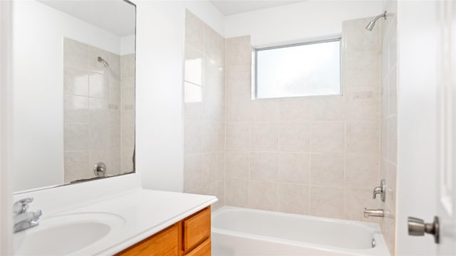 bathroom featuring tiled shower / bath and vanity