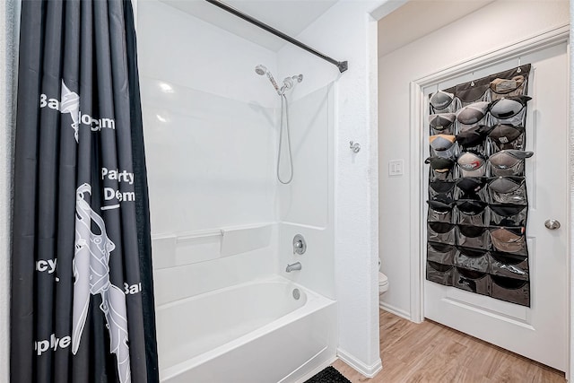 bathroom featuring hardwood / wood-style flooring, toilet, and shower / bath combo with shower curtain