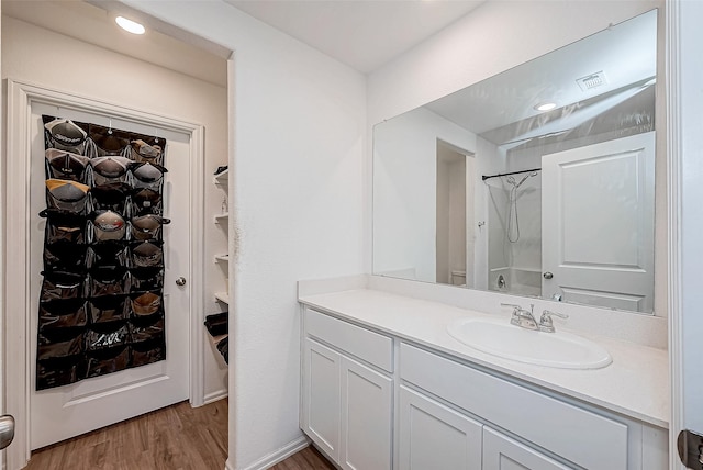 bathroom featuring vanity, wood-type flooring, and walk in shower