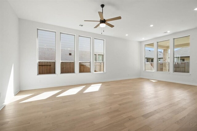 interior space featuring visible vents, light wood-type flooring, a healthy amount of sunlight, and ceiling fan