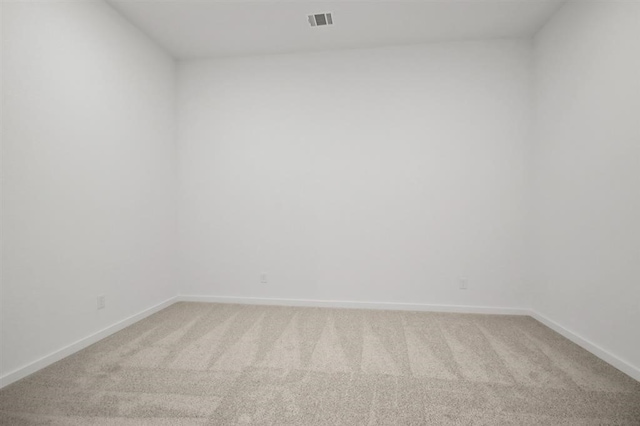 unfurnished room featuring light colored carpet, visible vents, and baseboards