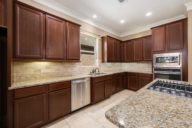 kitchen with light stone countertops, stainless steel appliances, crown molding, and sink