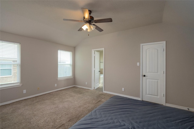 unfurnished bedroom with carpet flooring, connected bathroom, ceiling fan, and vaulted ceiling