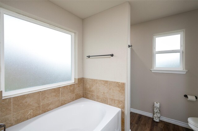 bathroom featuring a bath, wood-type flooring, and toilet