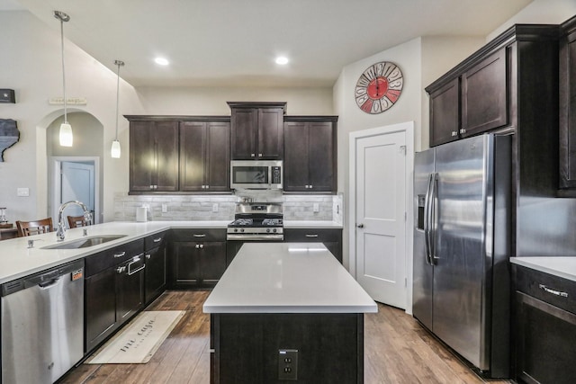 kitchen featuring hardwood / wood-style floors, sink, hanging light fixtures, and appliances with stainless steel finishes