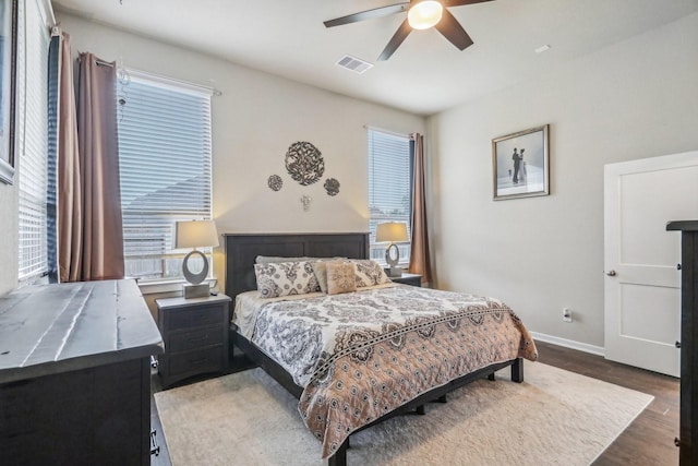 bedroom with dark hardwood / wood-style flooring and ceiling fan