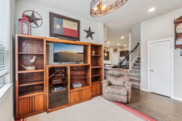 living area featuring wood-type flooring and a notable chandelier