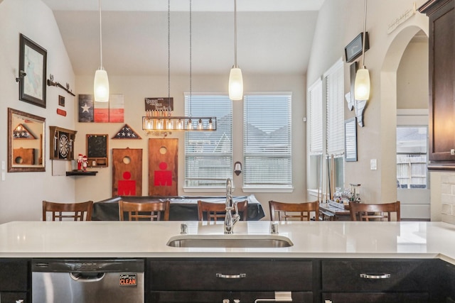 kitchen featuring vaulted ceiling, stainless steel dishwasher, and hanging light fixtures