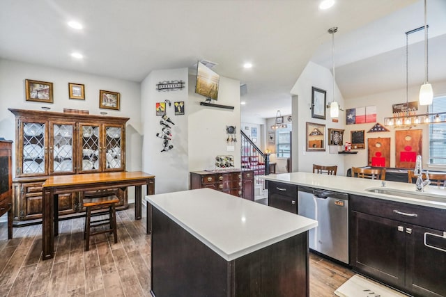 kitchen with sink, decorative light fixtures, dishwasher, a center island, and light hardwood / wood-style floors