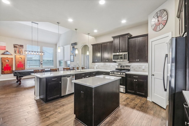 kitchen with dark hardwood / wood-style flooring, a center island, pendant lighting, and appliances with stainless steel finishes