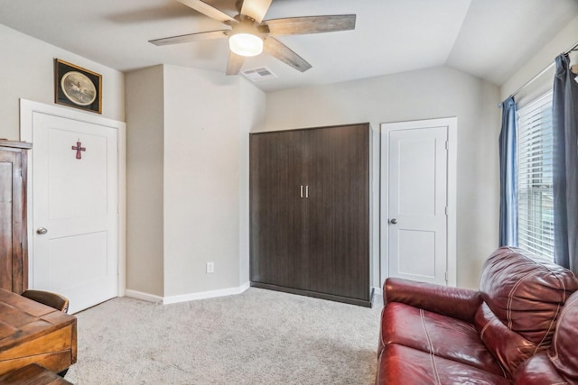 living area featuring light carpet, ceiling fan, and lofted ceiling