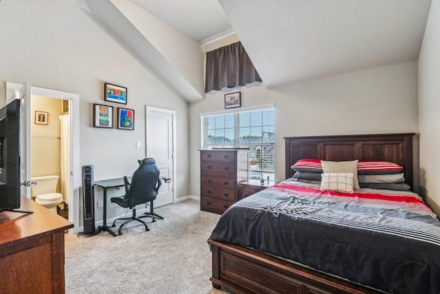 bedroom with ensuite bathroom, high vaulted ceiling, and light colored carpet