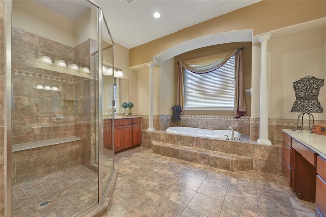 bathroom featuring ornate columns, plus walk in shower, and vanity