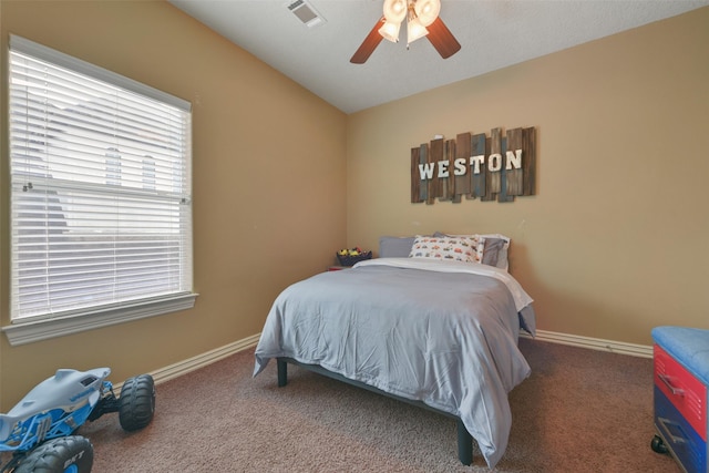 carpeted bedroom with ceiling fan and vaulted ceiling