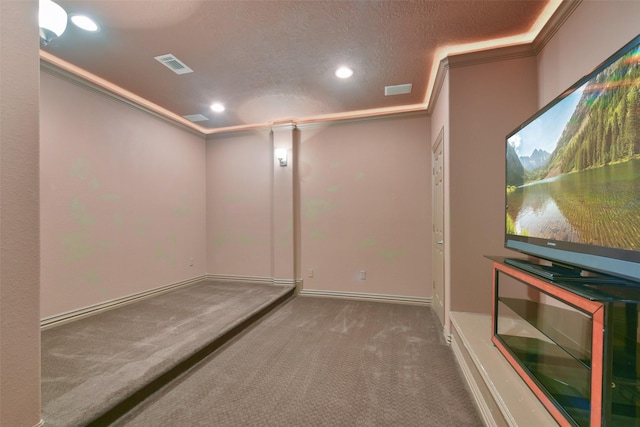 home theater featuring carpet floors, a textured ceiling, and ornamental molding