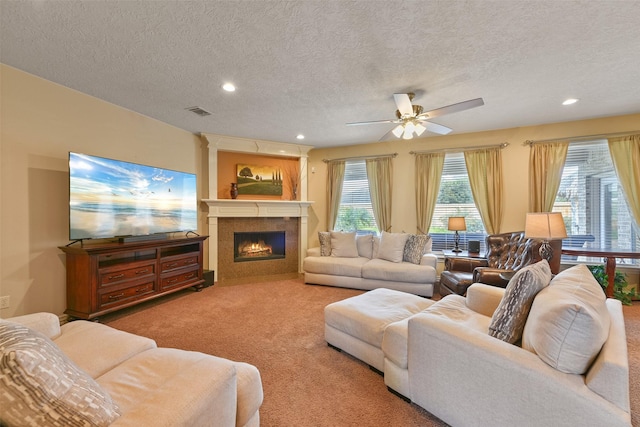 carpeted living room featuring ceiling fan and a textured ceiling