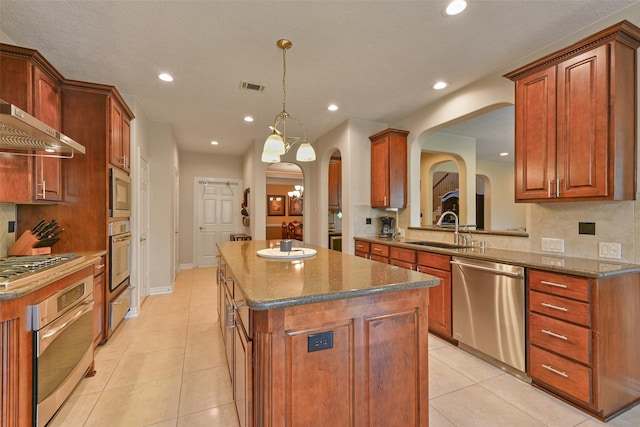 kitchen with appliances with stainless steel finishes, sink, decorative light fixtures, a notable chandelier, and a center island