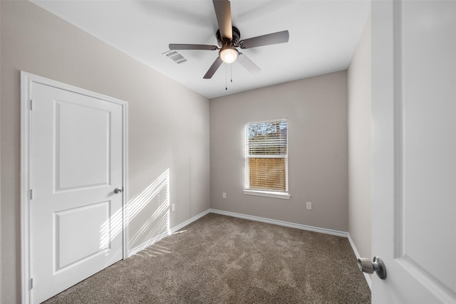 spare room featuring ceiling fan and carpet floors