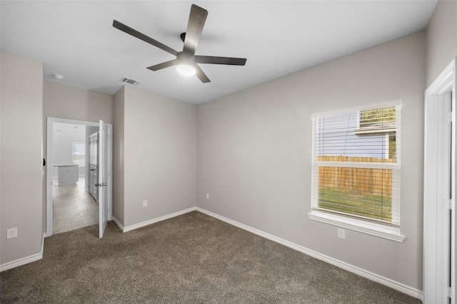 unfurnished bedroom with dark colored carpet and ceiling fan