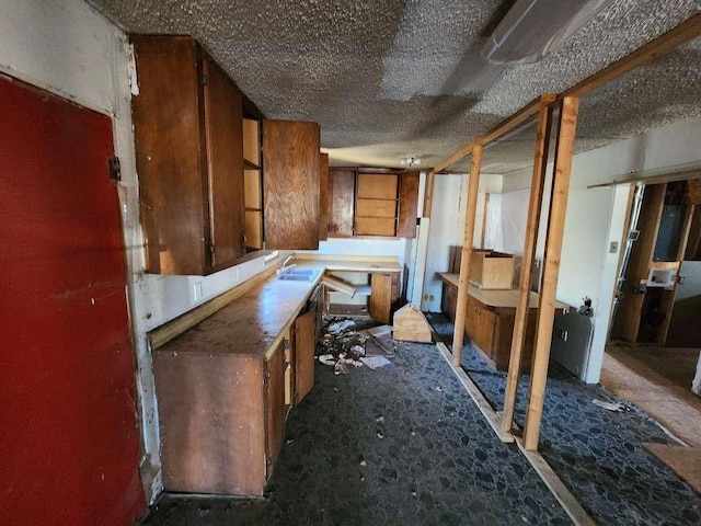 miscellaneous room featuring a textured ceiling and sink