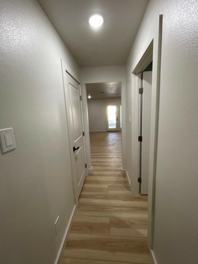 hallway with light hardwood / wood-style flooring