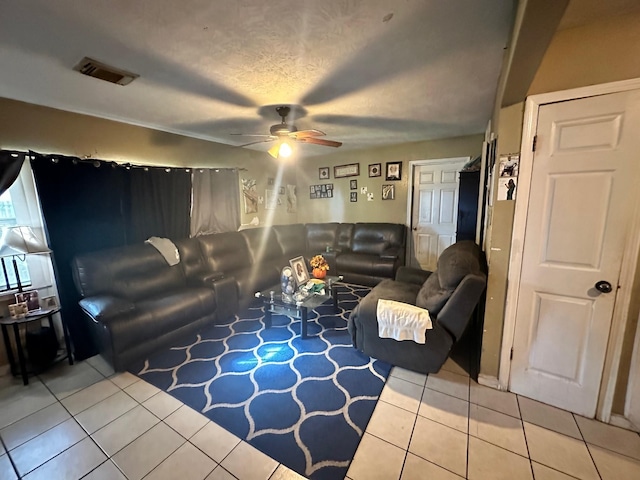 tiled living room with ceiling fan and a textured ceiling