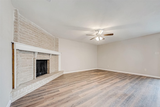 unfurnished living room featuring a fireplace, hardwood / wood-style flooring, and ceiling fan