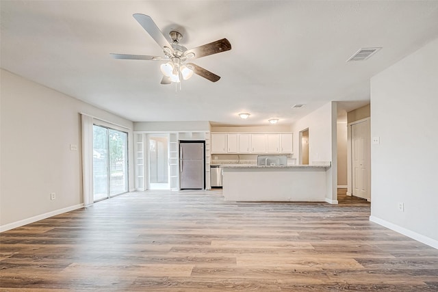 unfurnished living room with ceiling fan and light wood-type flooring