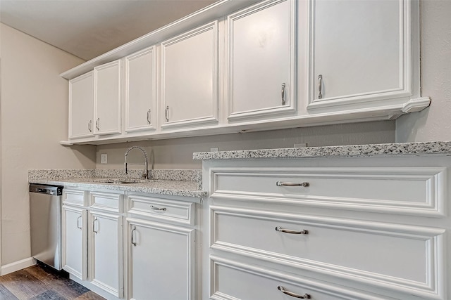 kitchen featuring stainless steel dishwasher, light stone counters, white cabinets, and dark wood-type flooring