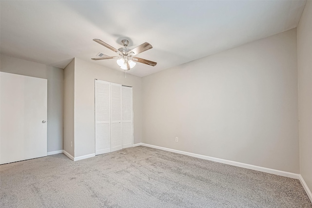 unfurnished bedroom featuring ceiling fan, light colored carpet, and a closet