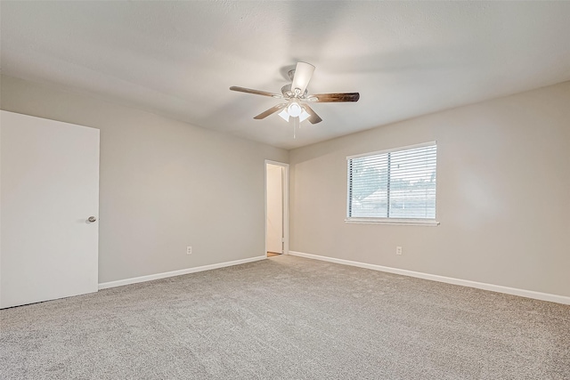 spare room with ceiling fan and carpet