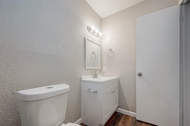 bathroom with hardwood / wood-style floors, vanity, and toilet