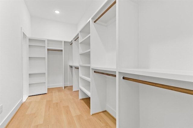 walk in closet with light hardwood / wood-style floors