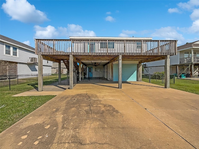 back of property with a carport, a garage, a deck, and a lawn