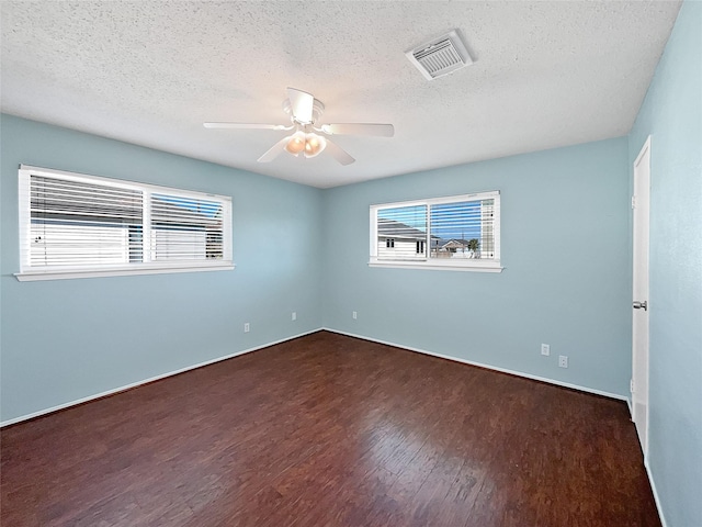 spare room featuring ceiling fan, dark hardwood / wood-style flooring, and a textured ceiling