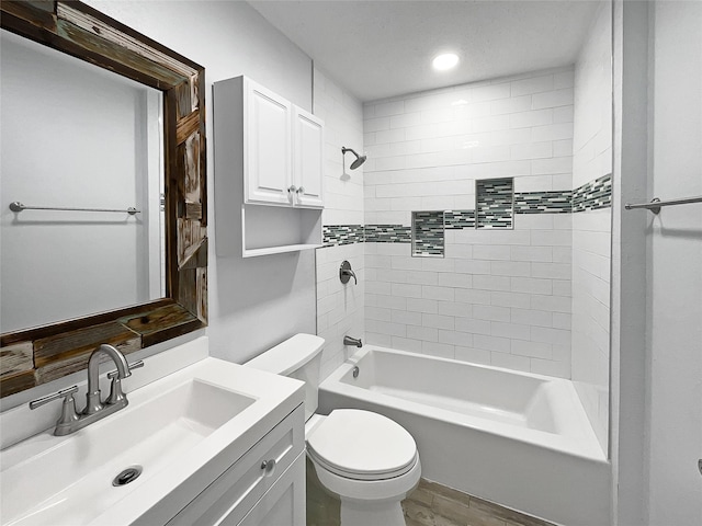 full bathroom with vanity, wood-type flooring, tiled shower / bath combo, and toilet