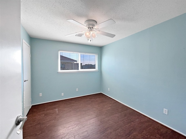 empty room with a textured ceiling, dark hardwood / wood-style flooring, and ceiling fan