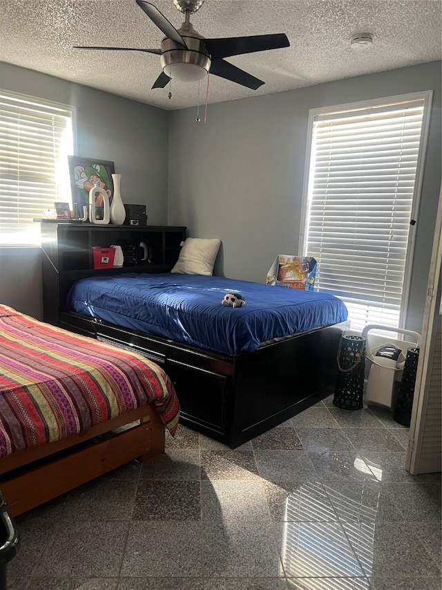 bedroom featuring ceiling fan and a textured ceiling