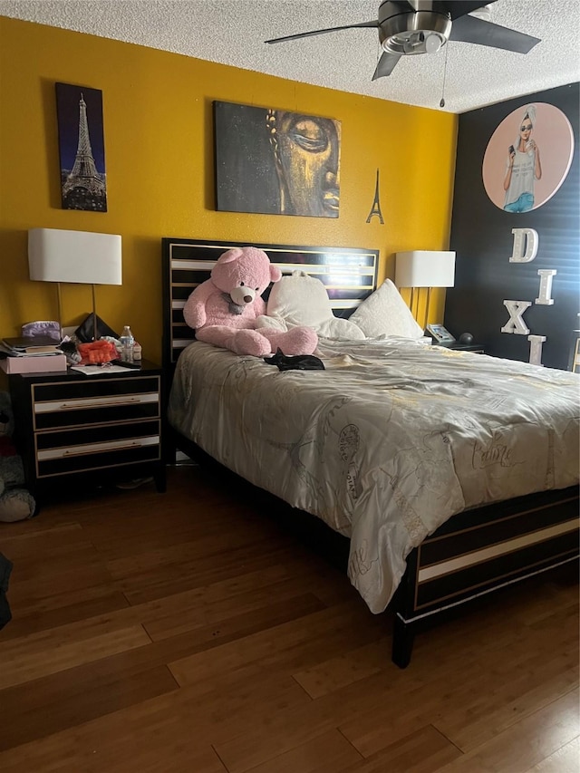 bedroom featuring ceiling fan, a textured ceiling, and dark wood-type flooring