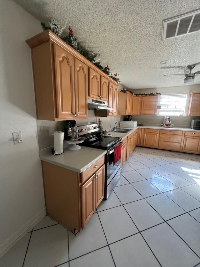 kitchen featuring a textured ceiling, sink, stainless steel range with electric cooktop, and light tile patterned floors