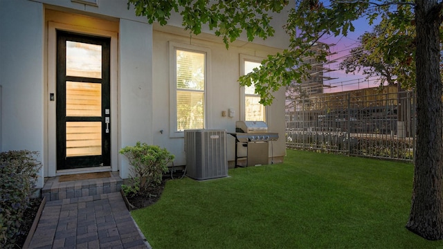 yard at dusk featuring central AC unit