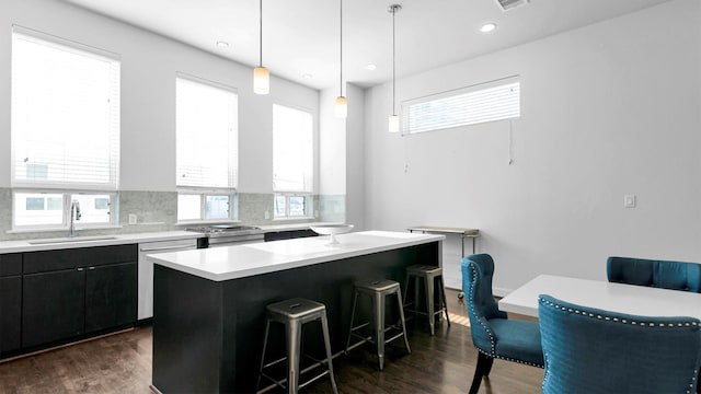 kitchen with a center island, hanging light fixtures, a wealth of natural light, and dark wood-type flooring