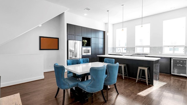 dining area with dark hardwood / wood-style flooring and beverage cooler