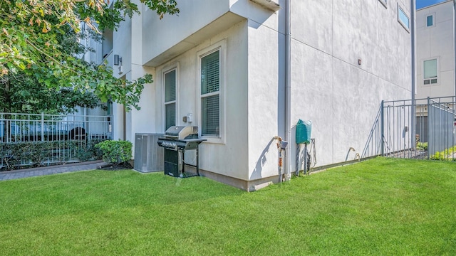 view of home's exterior featuring central AC and a yard