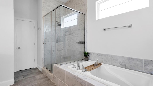 bathroom featuring hardwood / wood-style flooring and separate shower and tub