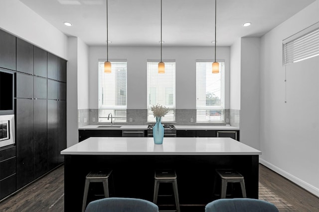 3111 Leeland St, Houston, TX 77003 - kitchen featuring stainless steel gas stove, a kitchen bar, backsplash, light countertops, and recessed lighting