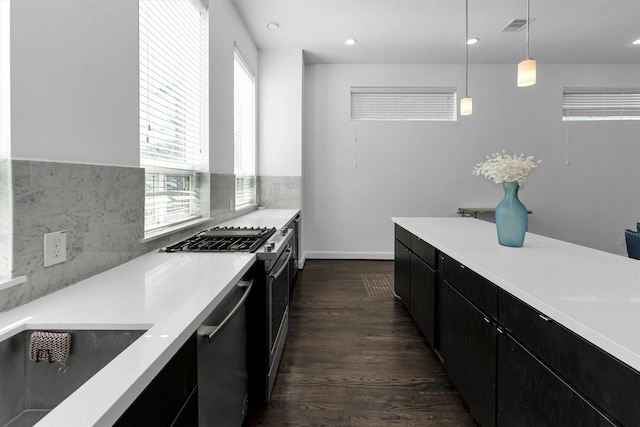 3111 Leeland St, Houston, TX 77003 - kitchen with dark cabinetry, pendant lighting, stainless steel appliances, light countertops, and dark wood-style flooring