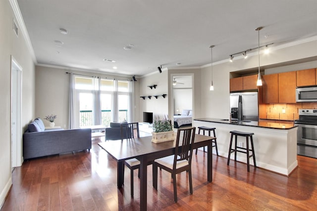 dining room with ceiling fan, crown molding, and dark wood-type flooring