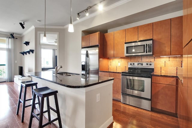 300 St Joseph Pkwy Unit 318, Houston, TX 77002 - kitchen with stainless steel appliances, a sink, ornamental molding, dark wood-style floors, and brown cabinets